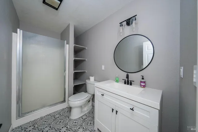 a bathroom with a sink vanity mirror and toilet