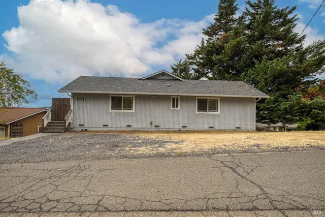 a view of a house with a outdoor space and wooden fence