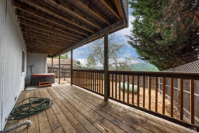 a view of roof deck with wooden floor and fence with a barbeque