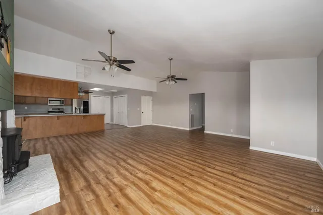 a view of a room with a ceiling fan and wooden floor