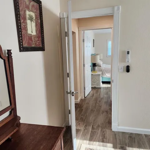 a view of a hallway with wooden floor and a living room
