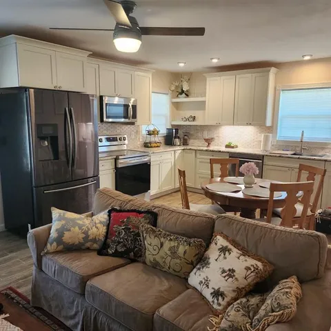 a kitchen with stainless steel appliances granite countertop a refrigerator and white cabinets