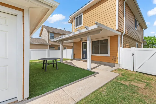 a backyard of a house with table and chairs