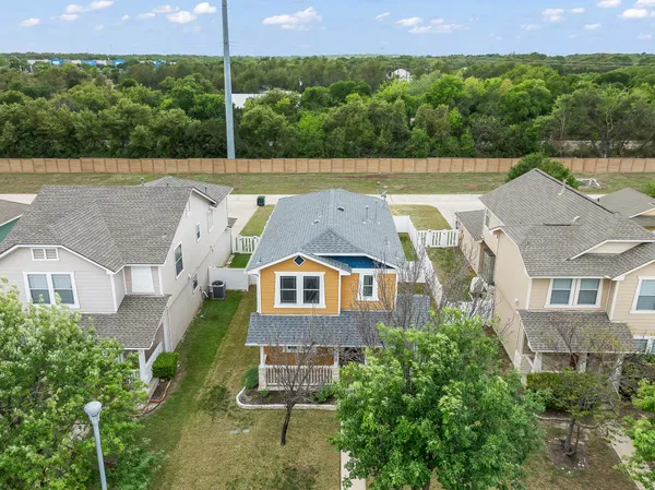 an aerial view of a house with a yard and a large tree