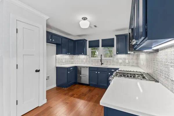 a kitchen with stainless steel appliances granite countertop wooden cabinets a sink and a stove