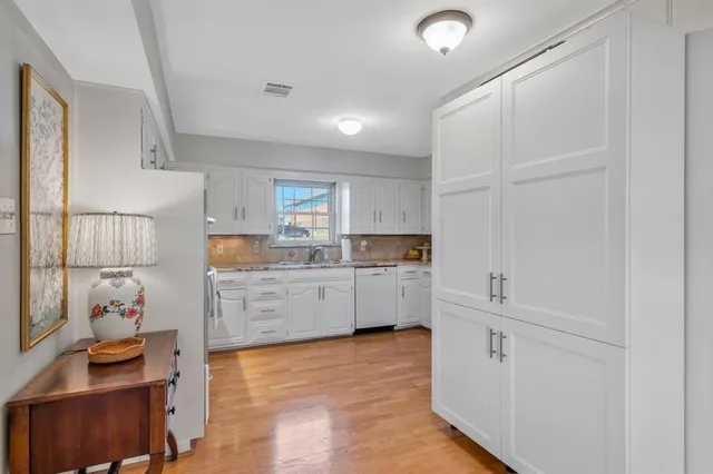a kitchen with white cabinets and window