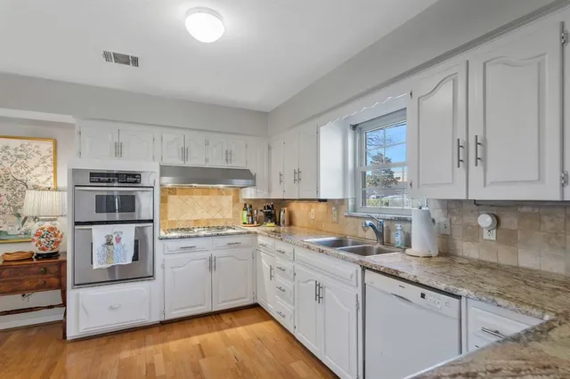 a kitchen with granite countertop white cabinets and white appliances