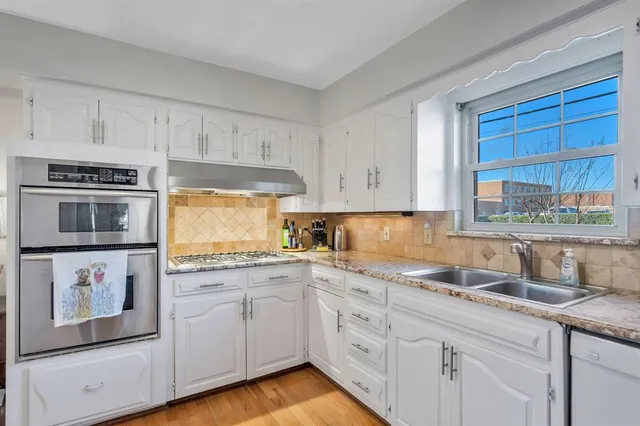 a kitchen with granite countertop white cabinets and white appliances