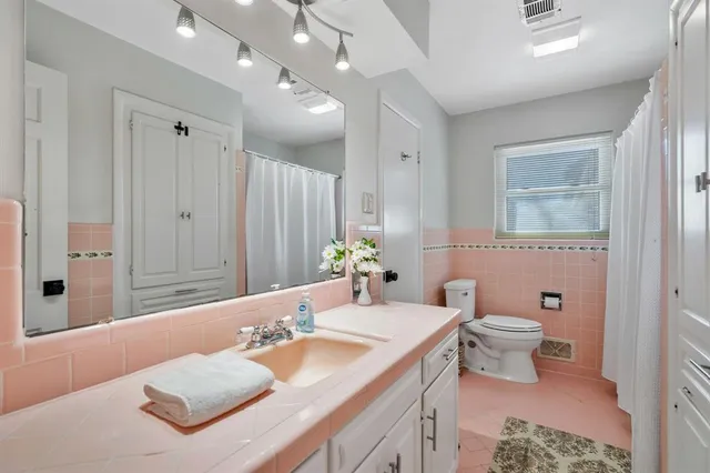 a bathroom with a granite countertop sink a toilet and a large mirror