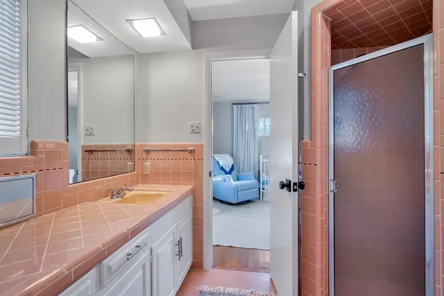a spacious bathroom with a granite countertop sink and a mirror