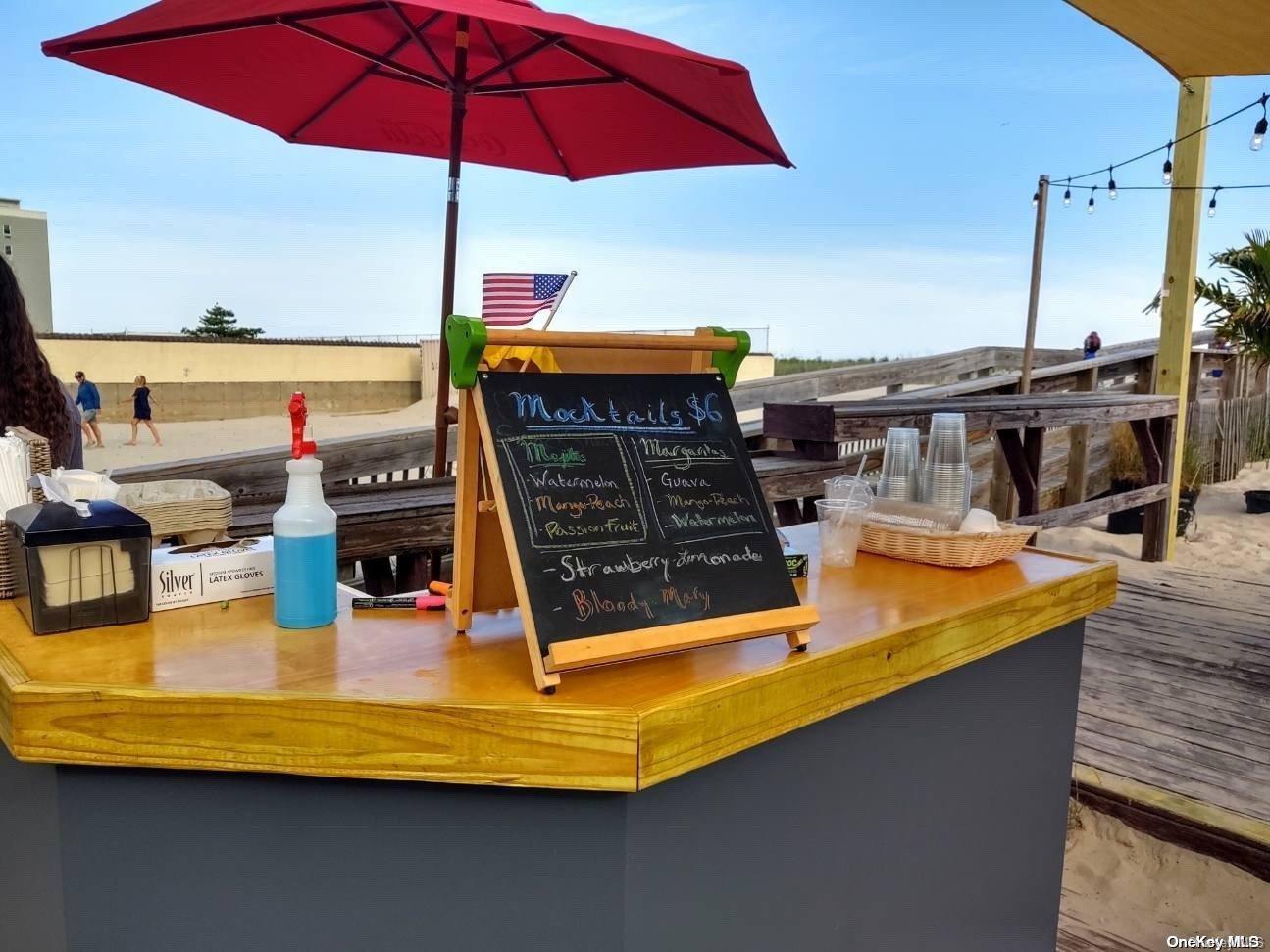 813 Shore Road Long Beach, NY 11561 - Photo 23 of 33 a view of a swimming pool with a table and chairs under an umbrella