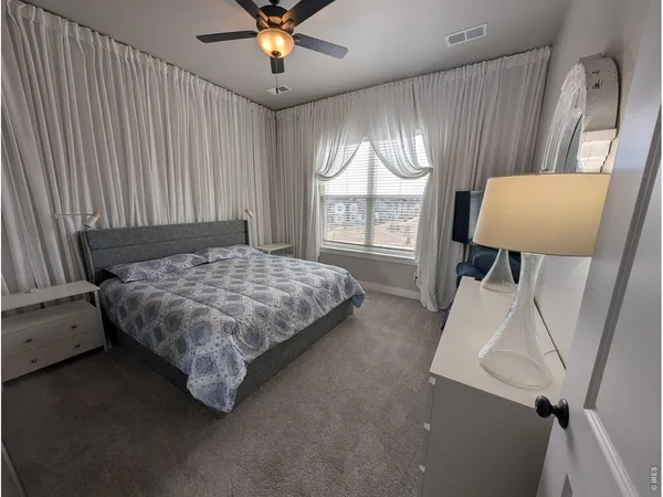 a bedroom with a bed window and a chandelier