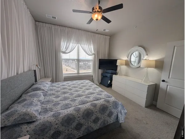 a bed sitting in a spacious bedroom next to a window