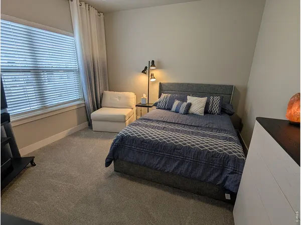 a bedroom with a bed and a couch next to a window