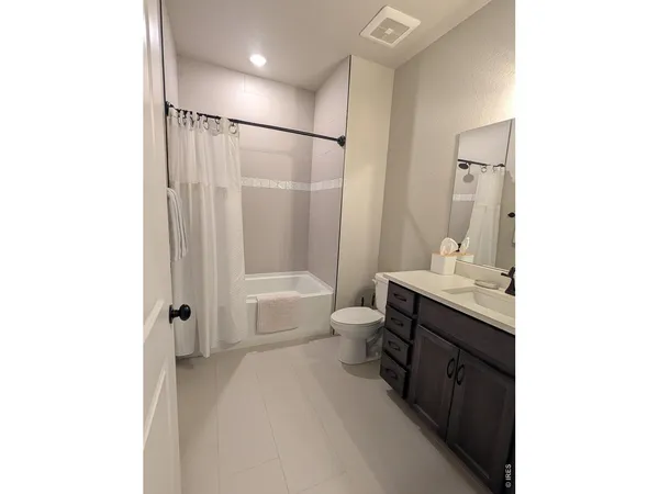 a spacious bathroom with a bathtub shower sink vanity and toilet