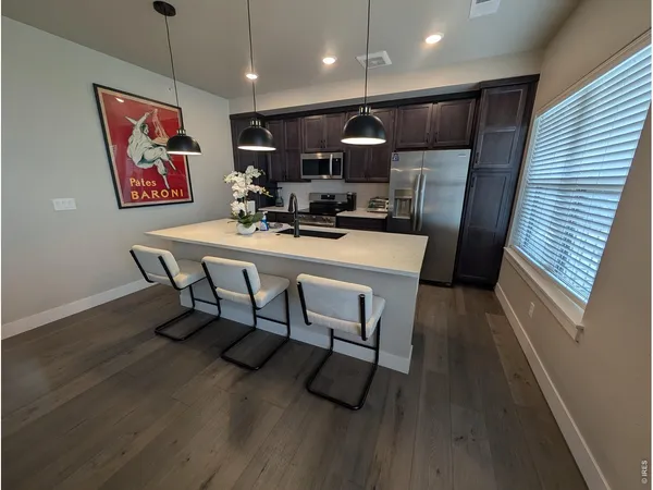 a view of a dining room with furniture wooden floor and kitchen view