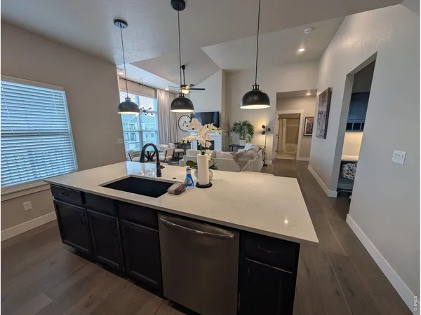 a kitchen with stainless steel appliances a center island wooden floor cabinets and a window