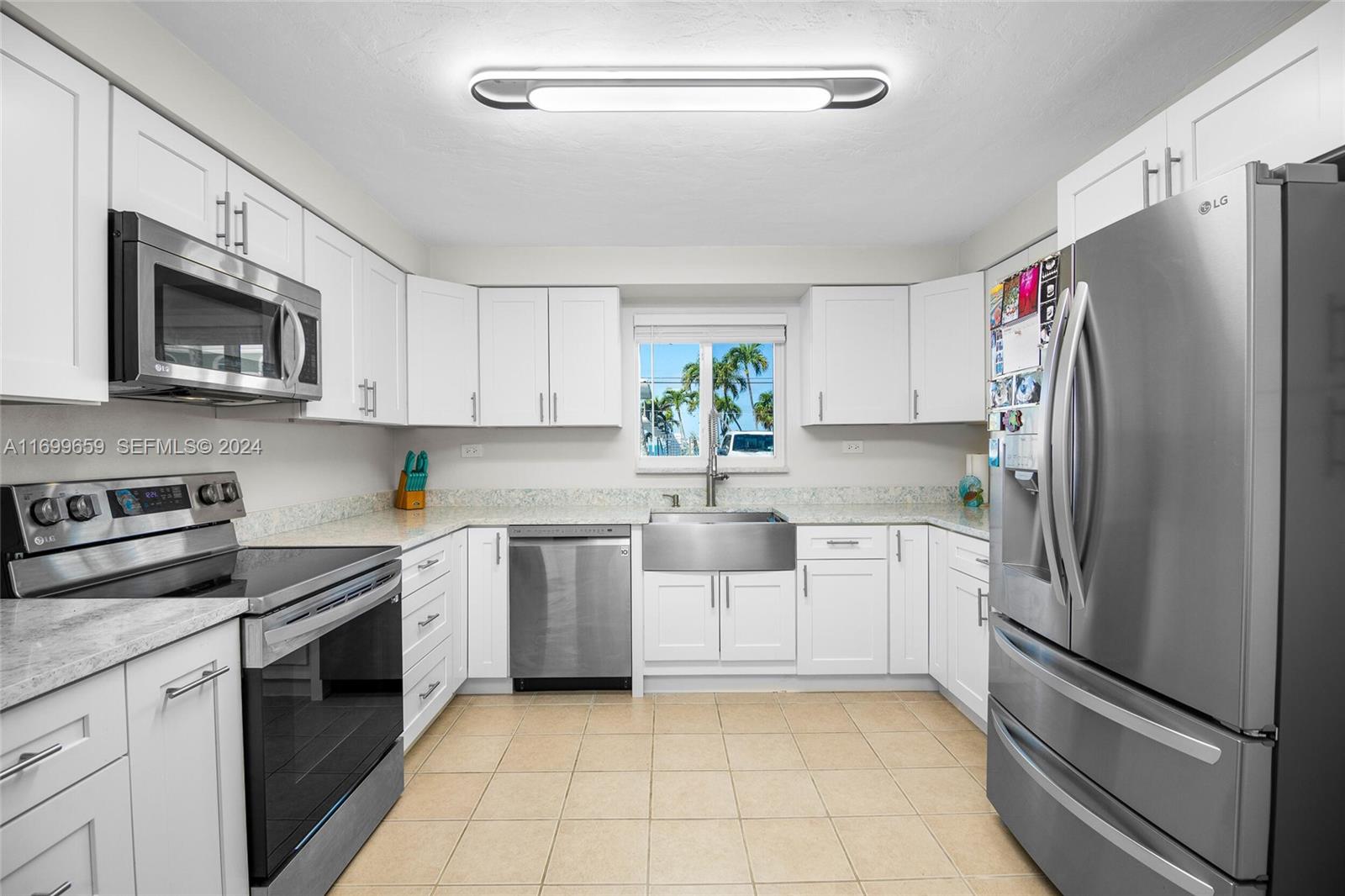 7951 Gulfstream Boulevard Marathon, FL 33050 - Photo 12 of 60 a kitchen with white cabinets stainless steel appliances and a window