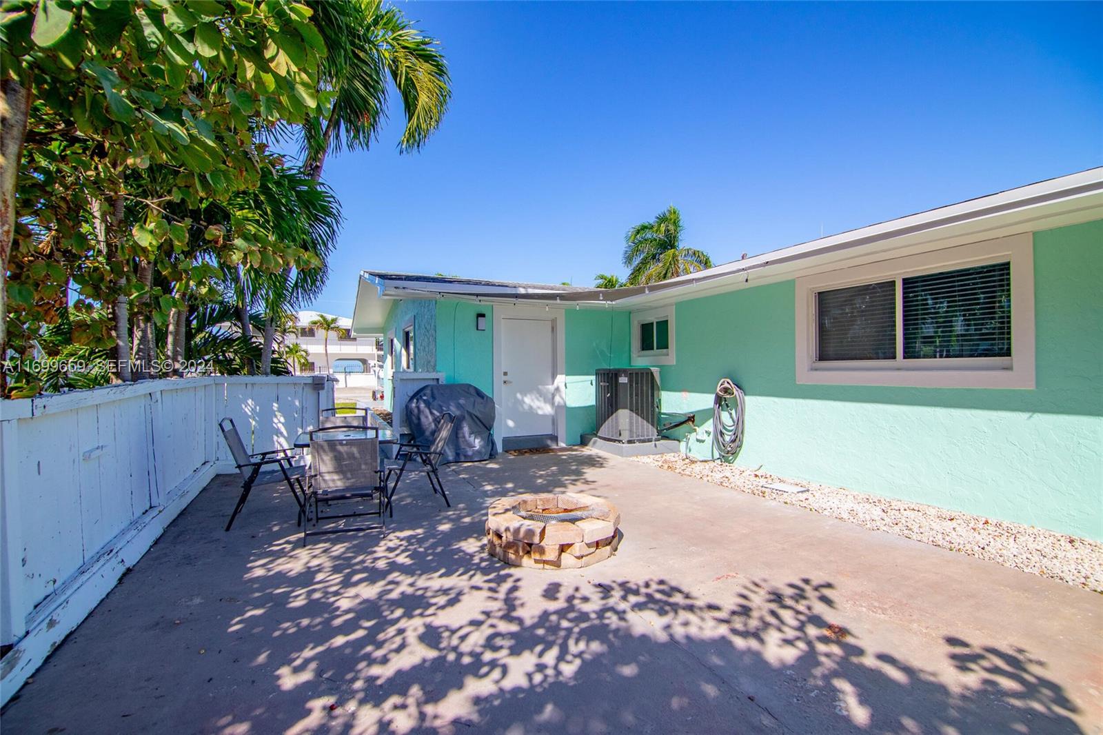 7951 Gulfstream Boulevard Marathon, FL 33050 - Photo 40 of 60 a view of a patio with table and chairs potted plants and wooden fence