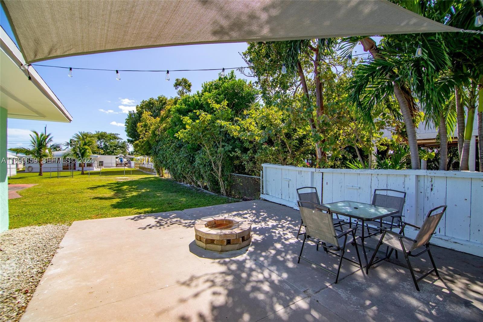 7951 Gulfstream Boulevard Marathon, FL 33050 - Photo 42 of 60 a view of a backyard with table and chairs under an umbrella