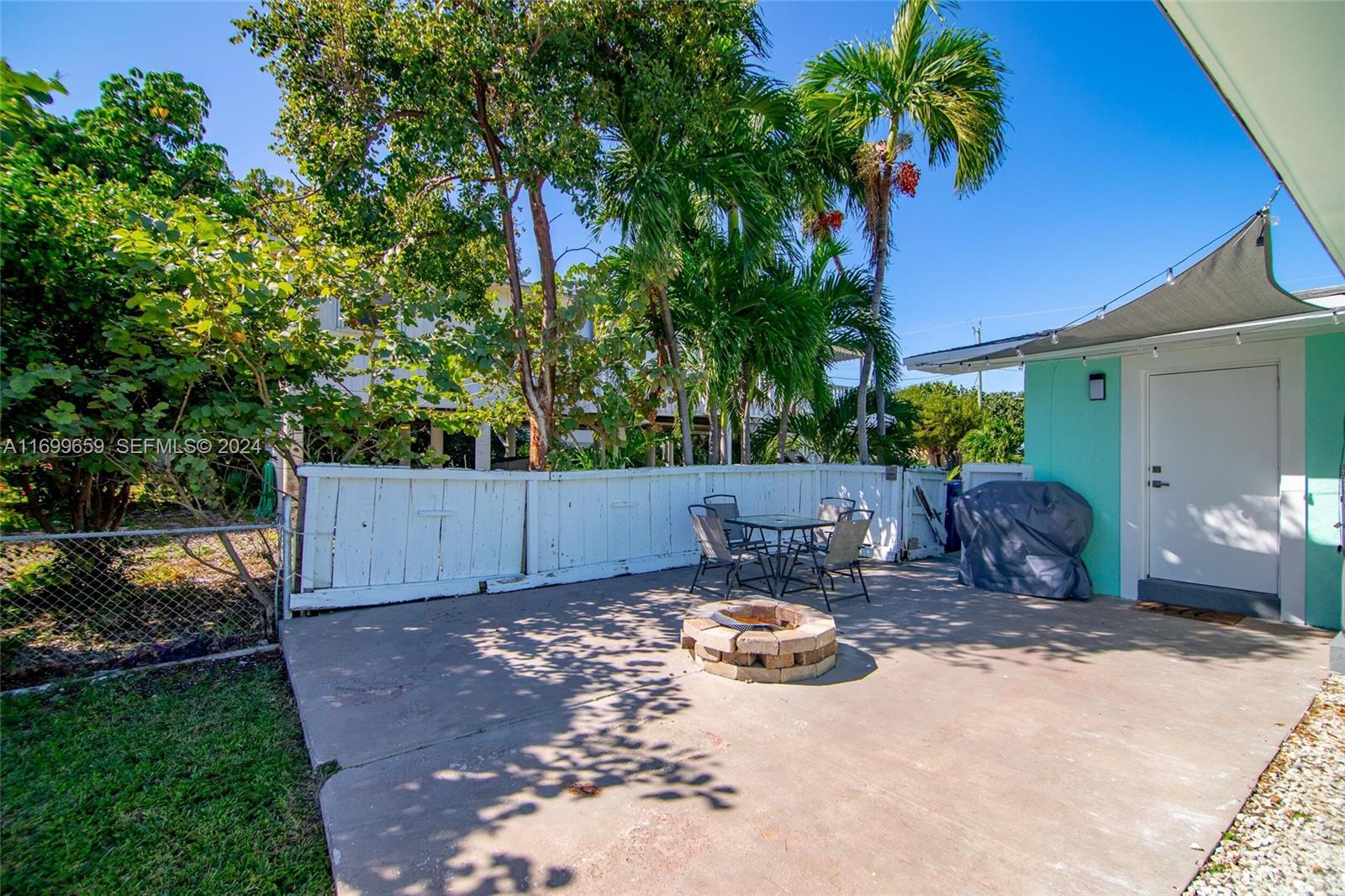 7951 Gulfstream Boulevard Marathon, FL 33050 - Photo 43 of 60 a view of a backyard with table and chairs and a fire pit