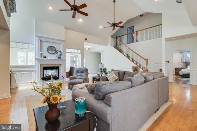 a view of a dining room and livingroom with furniture wooden floor a chandelier