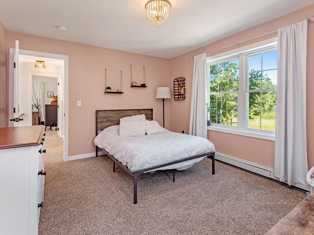 447 Ashby Road Ashburnham, MA 01430 - Photo 22 of 37 a bedroom with a bed and a chandelier