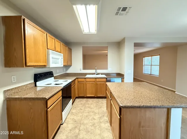 a kitchen with a stove a sink a microwave and refrigerator