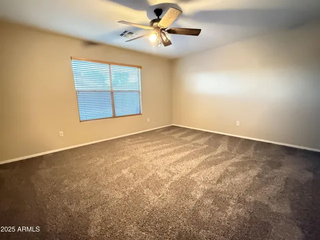 an empty room with windows and fan