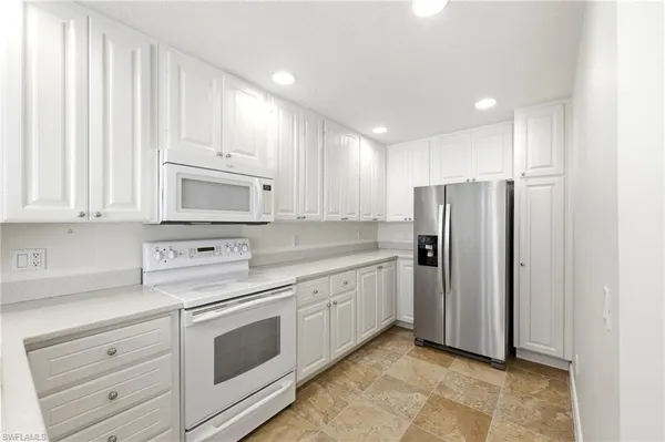 a kitchen with stainless steel appliances white cabinets and a refrigerator
