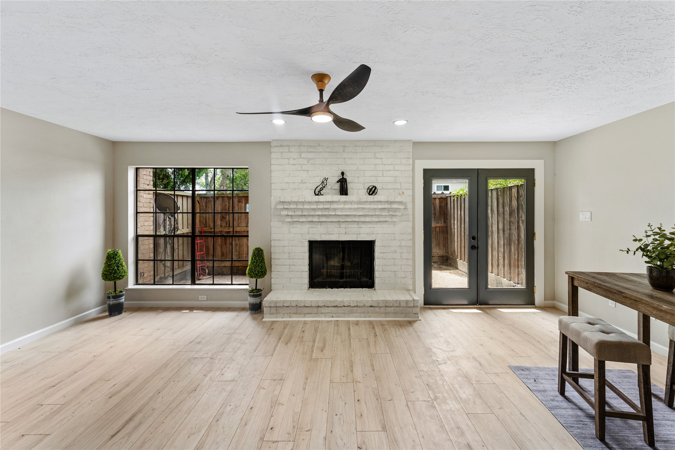 9425 Fondren Road Houston, TX 77074 - Photo 14 of 29 The fireplace is the focal point of this versatile area. A huge window and glass French doors allow lots of natural lighting into the room