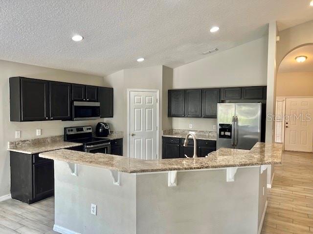 2749 Callaway Lane Kissimmee, FL 34744 - Photo 13 of 30 a kitchen with stainless steel appliances wooden cabinets a sink and a stove