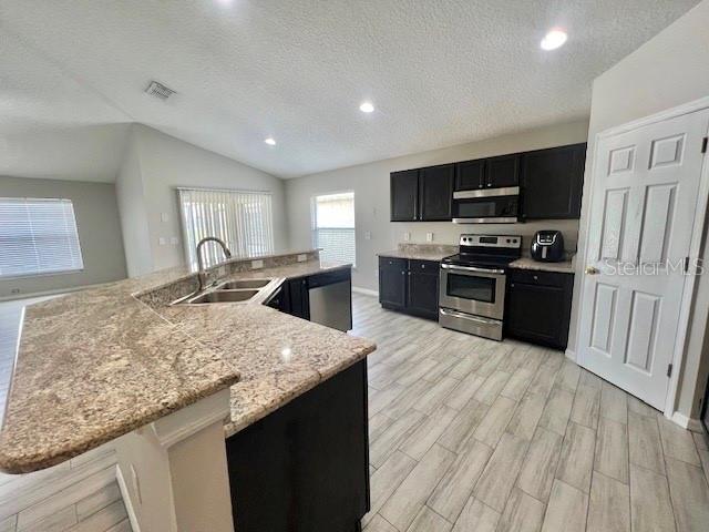 2749 Callaway Lane Kissimmee, FL 34744 - Photo 14 of 30 a kitchen with stainless steel appliances granite countertop a sink stove and refrigerator