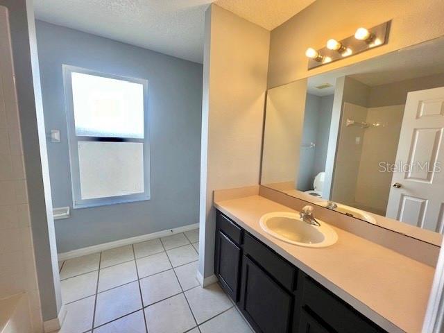 2749 Callaway Lane Kissimmee, FL 34744 - Photo 23 of 30 a bathroom with a sink a vanity and a mirror
