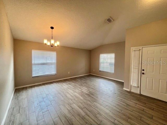 2749 Callaway Lane Kissimmee, FL 34744 - Photo 6 of 30 an empty room with wooden floor chandelier and windows