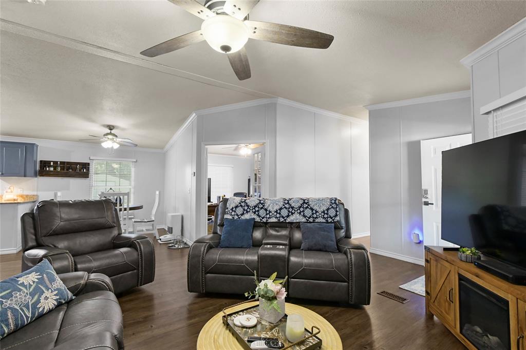 338 Fisherman Road Pottsboro, TX 75076 - Photo 5 of 24 Spacious open-concept living area featuring hardwood flooring, ceiling fans with integrated lighting, and a wood-finish entertainment center