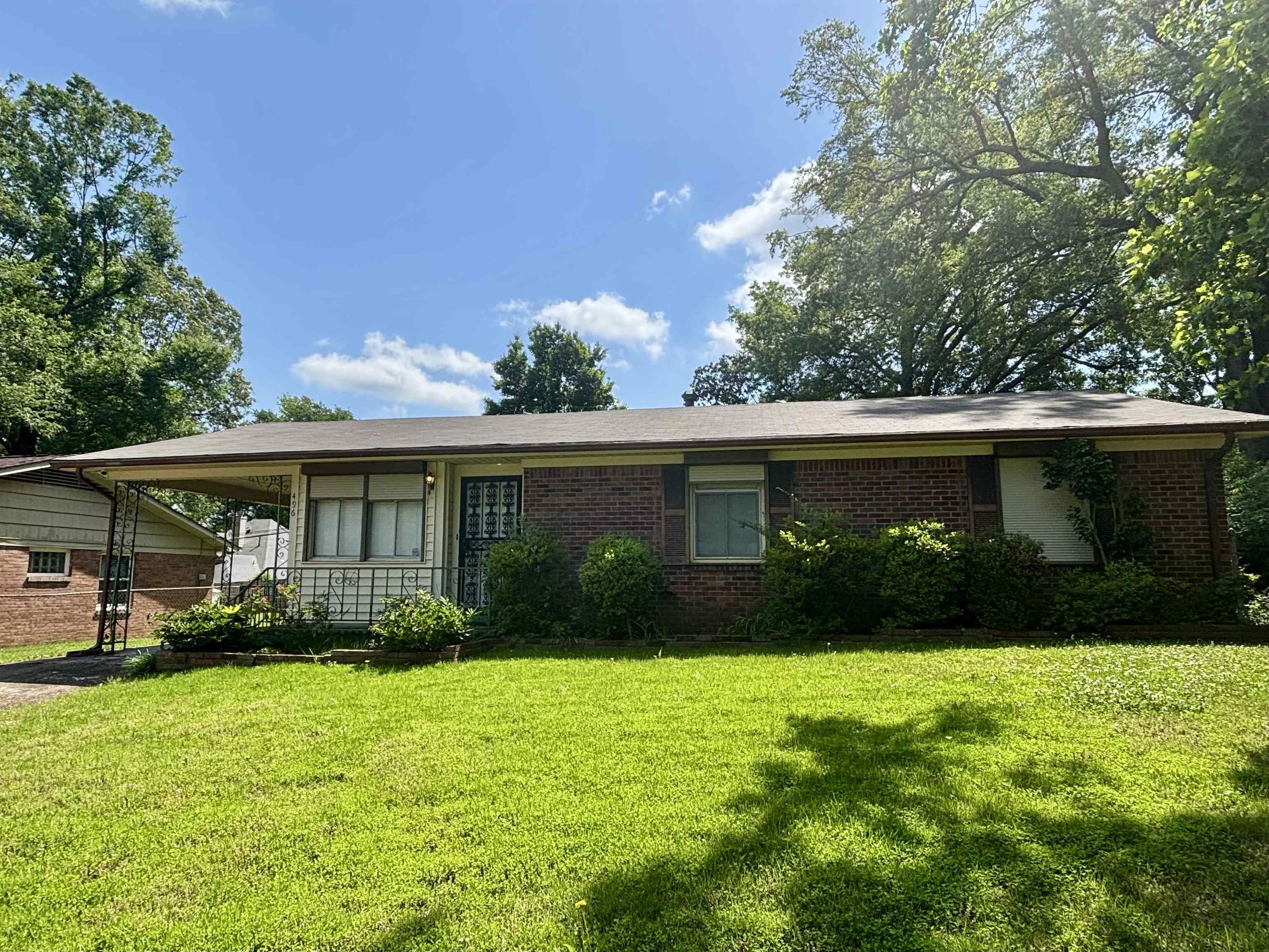 496 Chalmers Road Memphis, TN 38120 - Photo 1 of 20 View of front of home featuring brick siding, a front lawn, and a carport