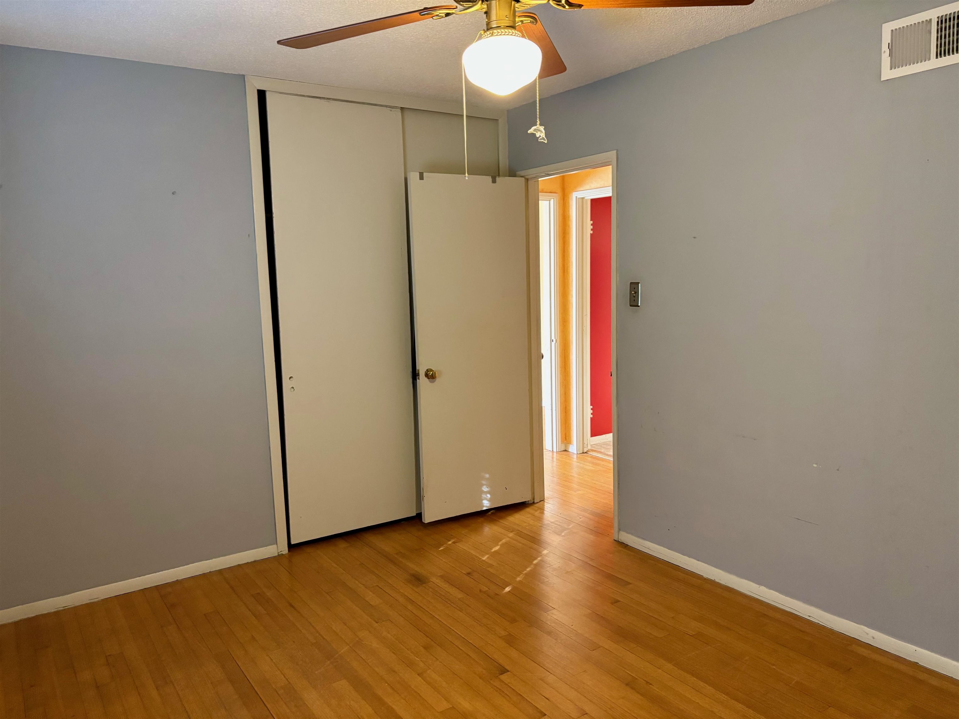 496 Chalmers Road Memphis, TN 38120 - Photo 14 of 20 Unfurnished bedroom with a ceiling fan, visible vents, baseboards, a closet, and light wood-style floors