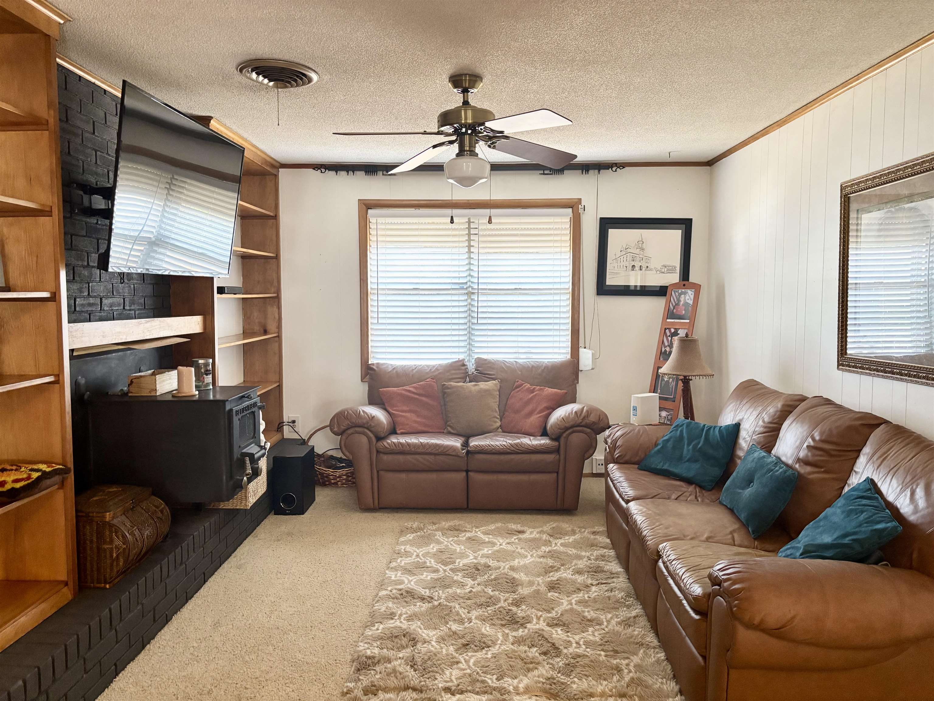496 Chalmers Road Memphis, TN 38120 - Photo 4 of 20 Living room with ceiling fan, carpet flooring, a textured ceiling, and a wood stove