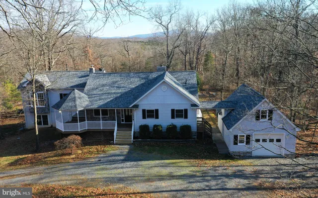 a view of a big house with large tree and windows