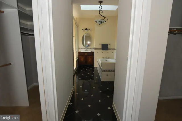 an empty room with windows and chandelier fan