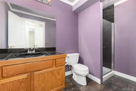 a bathroom with a granite countertop toilet sink and mirror
