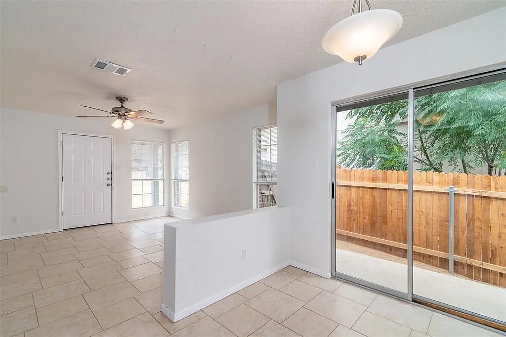 7229 Aldea Drive, Unit B Austin, TX 78745 - Photo 1 of 13 a view of an empty room with a window and chandelier fan