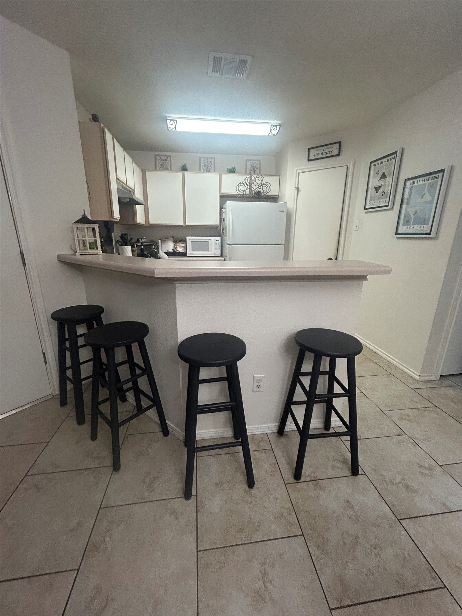 7229 Aldea Drive, Unit B Austin, TX 78745 - Photo 11 of 13 a kitchen with stainless steel appliances a table chairs microwave and sink