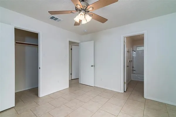 a view of an empty room with a ceiling fan