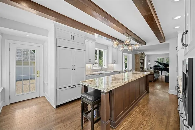 a dining hall with stainless steel appliances granite countertop a sink stove and wooden floor