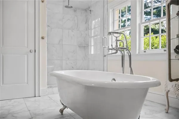a white bath tub sitting in a bathroom next to a window