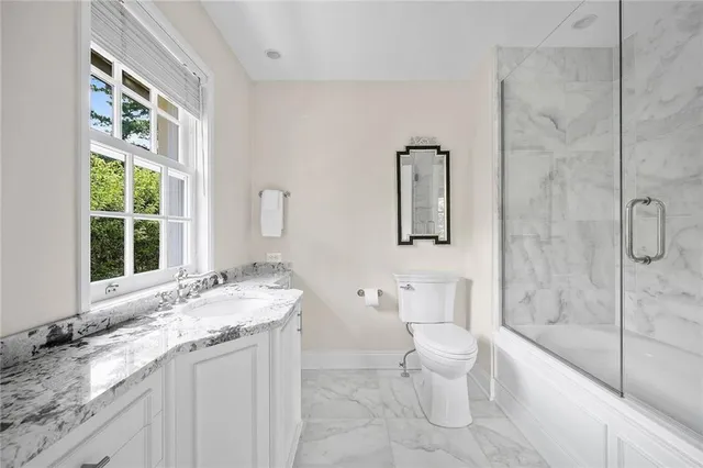 a bathroom with a granite countertop sink toilet and shower