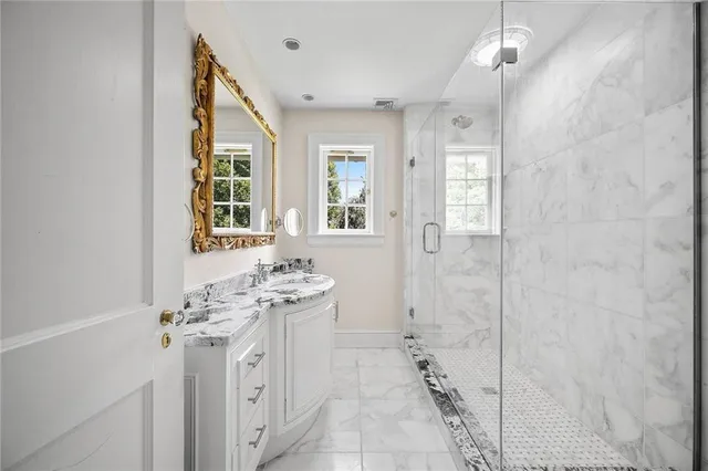 a bathroom with a sink a toilet a mirror and shower