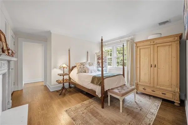 a spacious bedroom with a bed and wooden floor